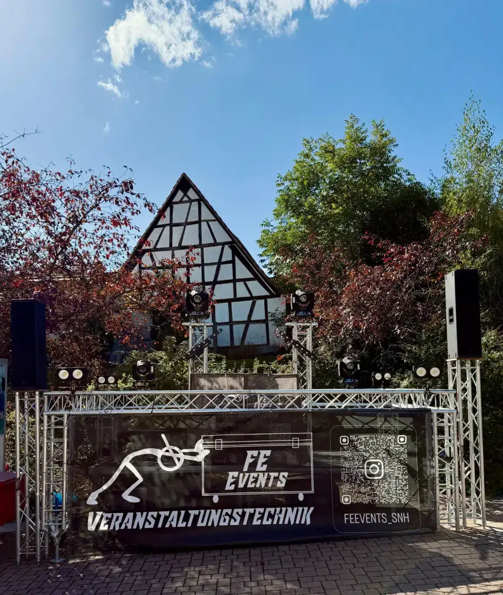 Traversenbühne mit Lautsprechern vor einem Fachwerkhaus