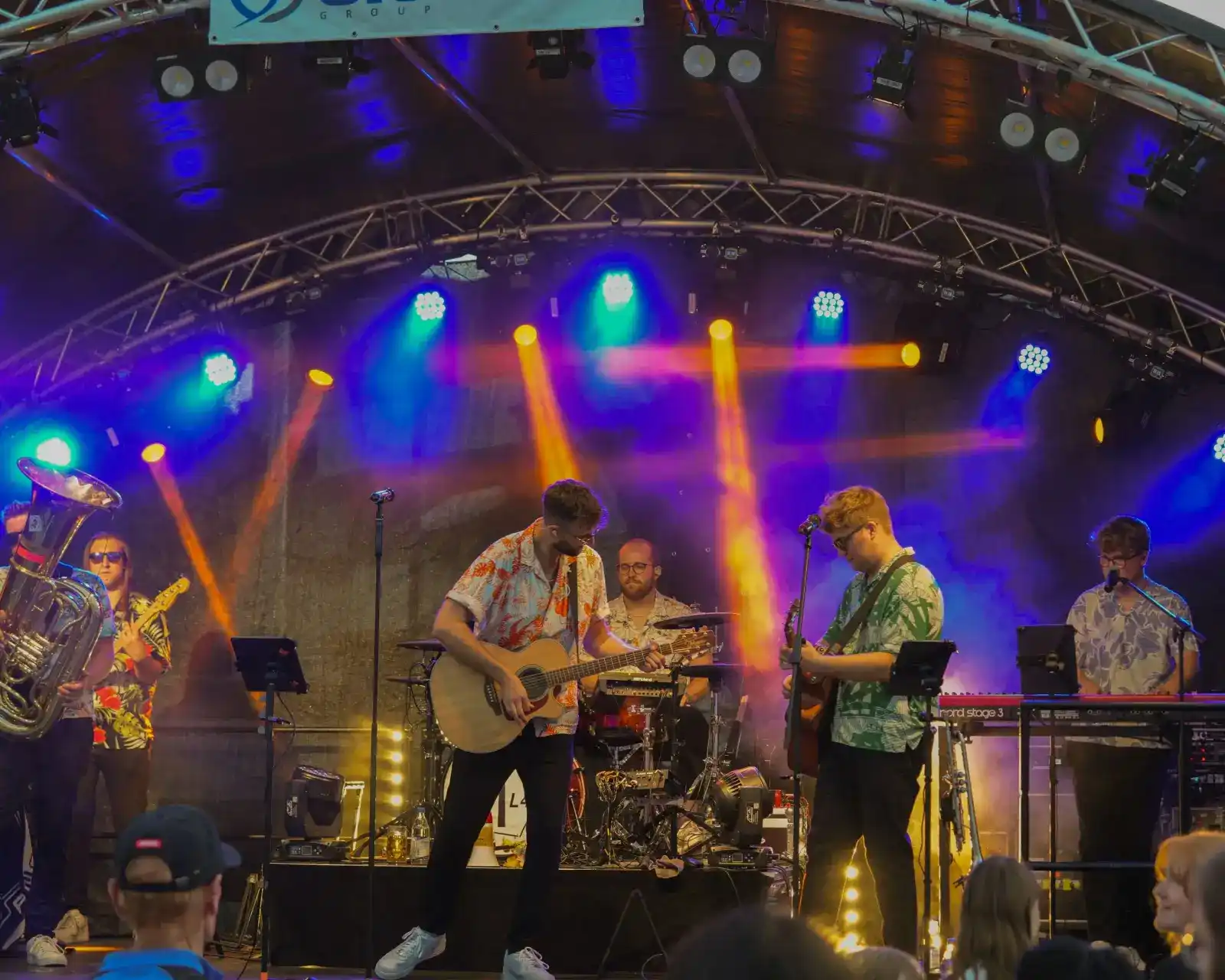 Bühne mit Bogendach und bunter Beleuchtung bei einem Konzert