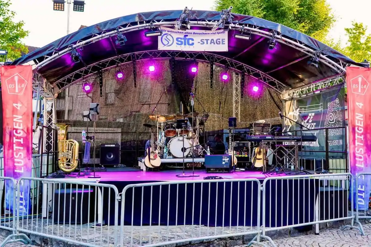 Bühne mit Bogendach, Schlagzeug und Keyboards, violett beleuchtet