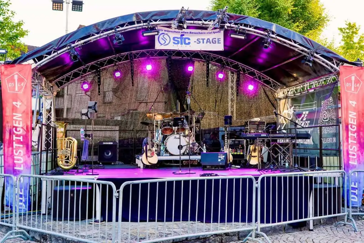 Bühne mit Bogendach, Schlagzeug und Keyboards, violett beleuchtet